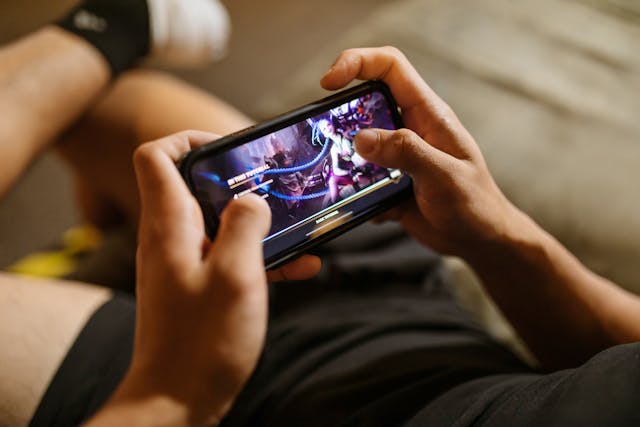Osoba igra igricu na telefonu